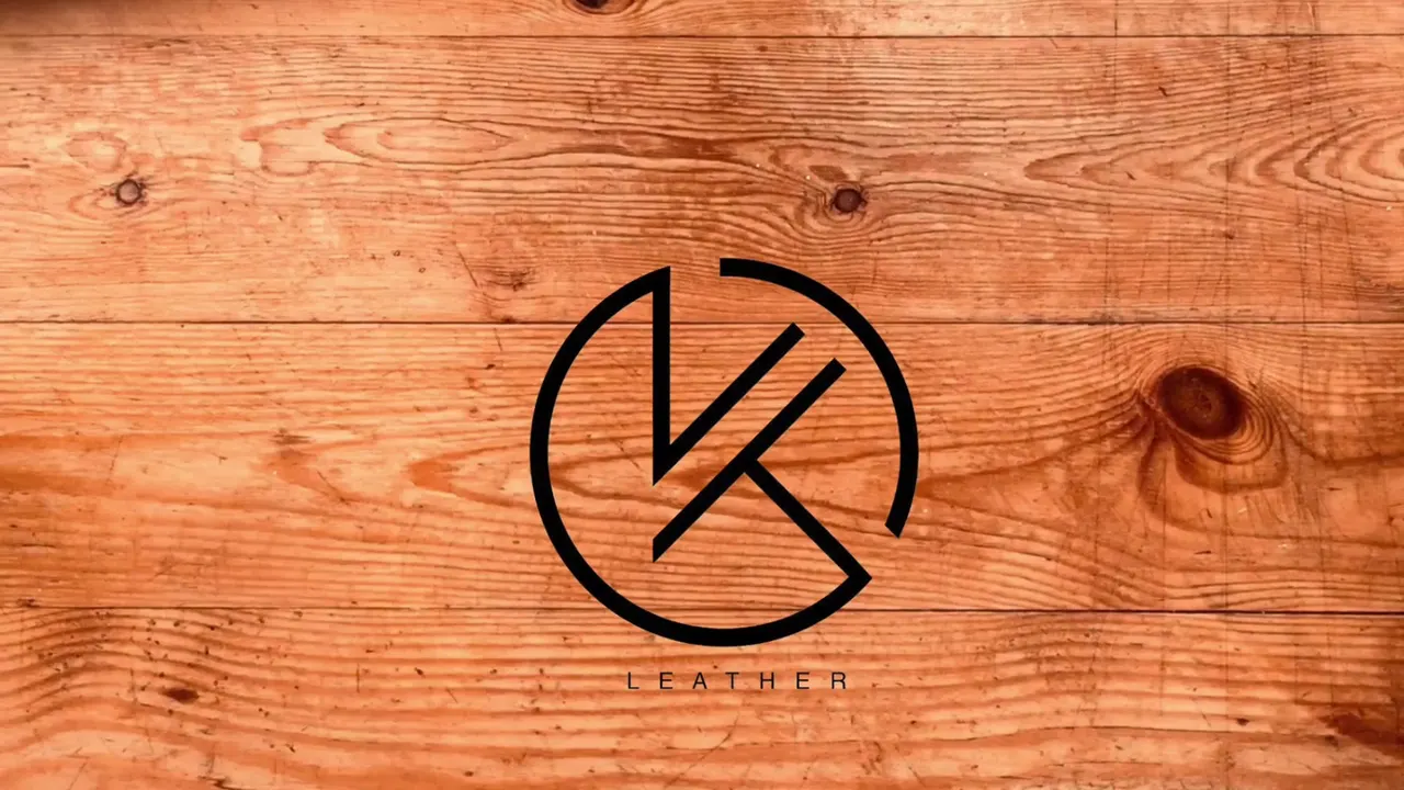 The KT Leather mark — a K and a T drawn inside a circle — above the word Leather, on a plank of warm orange pine